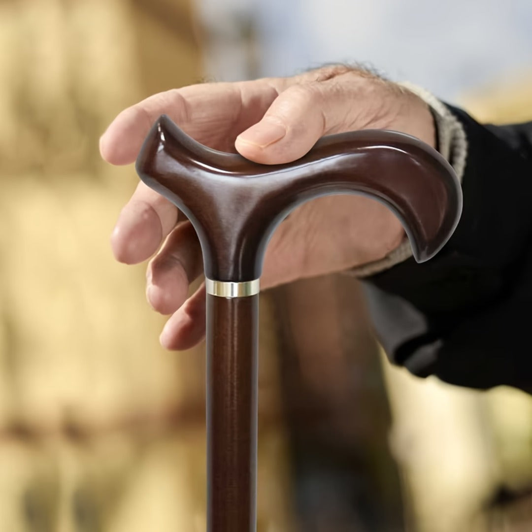 Dark Beech Derby Walking Cane with a hand resting on the Derby grip
