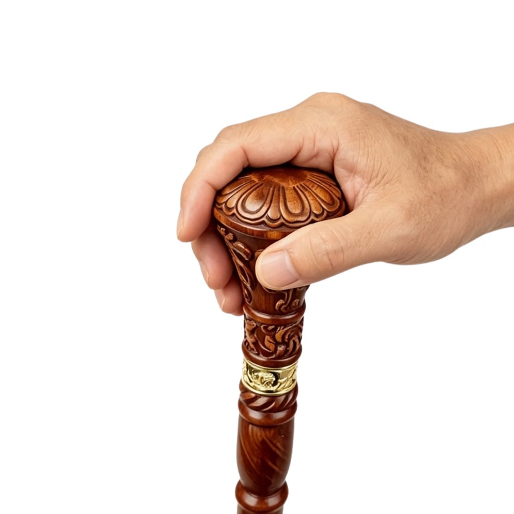 Carved knob handle held in the hand, showing the gold collar