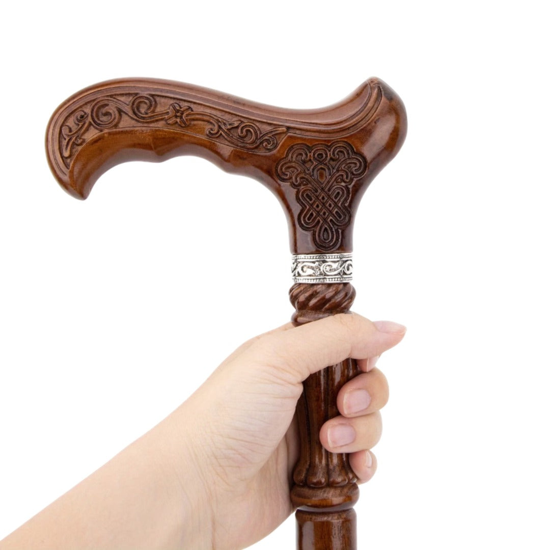 Hand Carved Walking Cane held in the hand, showing the carved collar section