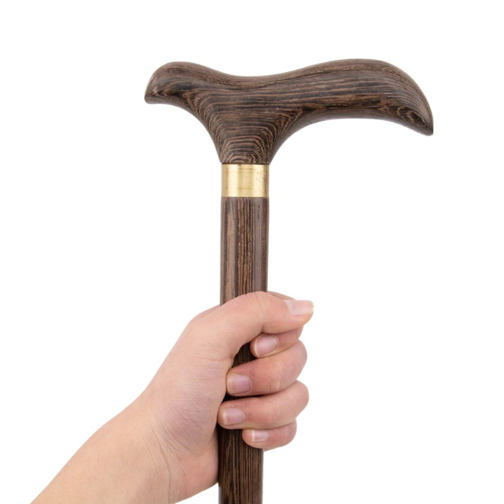 Brown walking stick handle held in the hand, showing the brass collar